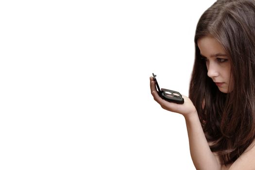 A beautiful brown haired  young girl holding makeup box and looking to the mirror, isolated over white background