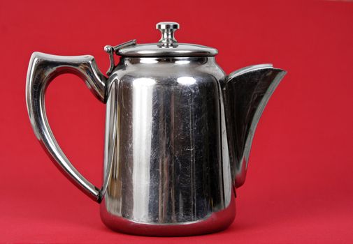 old stainless teapot, red background