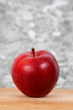 red apple on wood cutting plank