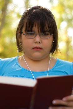 A nine year old girl studying from her text book for school
