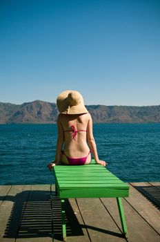 The pictue of the woman looking at the calm lake Laguna de apoyo