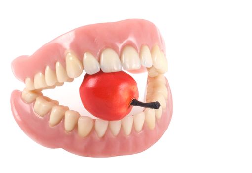 Dentures with little fake apple, isolated on a white background.