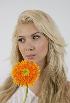 close-up of gorgeous woman holding gerbera against white background