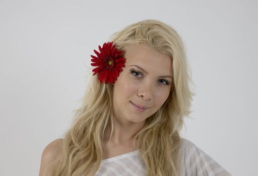 pretty model with bright red flower in her hair isolated with white background