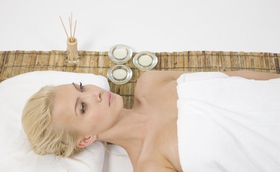 woman lying on massage mat on white background