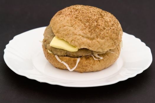 Sandwich on a white plate on a black background