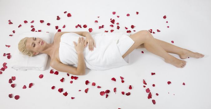 model lying with petals spread around on isolated studio pictures