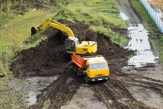 The dredge and the dumper truck work on building.