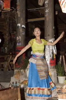 CHINA, YUNNAN PROVINCE, LIJIANG CITY - SEPTEMBER 13: Beautiful Tibetan girl performing traditional dance in bar, Suhe old town.