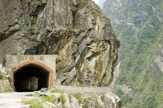 Sino-Tibetan mountains in Yunnan province, near Lijiang city, China. Old tunnel in mountains.