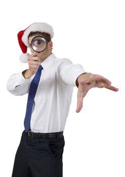 handsome businessman with santa hat and magnifier on white background