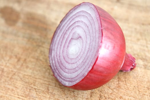 A sliced red onion on a wooden background