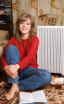 Woman sits on a carpet in a living room