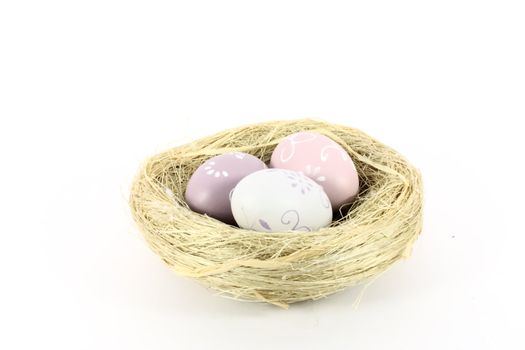 A bird nest with colored eggs isolated on white