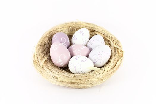 A bird nest with colored eggs isolated on white