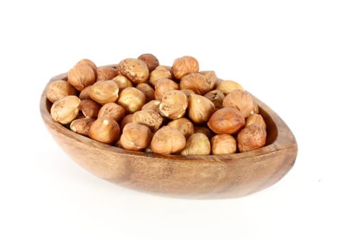 Wood bowl full of  hazelnuts, isolated on white