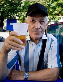 The elderly man with beer in park. A portrait