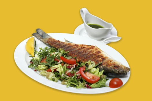 Grilled fish with vegetables and sauce.