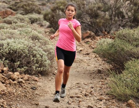 Woman running. Woman trail running outdoors on dirt single track in desert landscape in cross country running shoes.