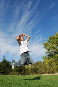 Boy expressing happiness by jumping in the park