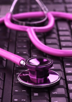image of a pink stethoscope on a black keyboard