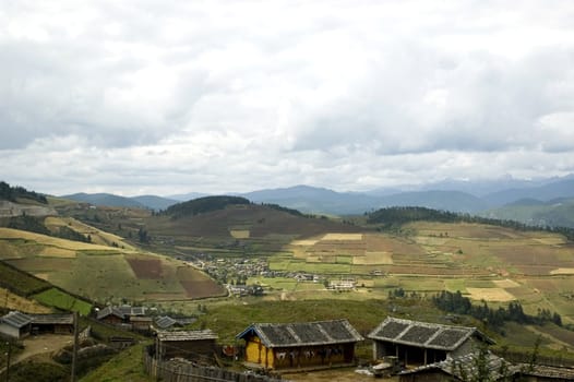 Small village in Yunnan province, near Shangrila town in China. Simple wooden houses and rice fields.