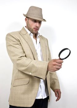 man with fedora hat and magnifier on isolated background
