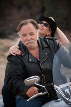 Fun couple riding a white motorcycle outside