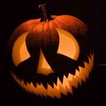 Carved Halloween pumpkin glowing in the dark.