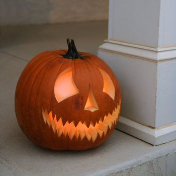 Carved Halloween pumpkin sitting on doorstep.