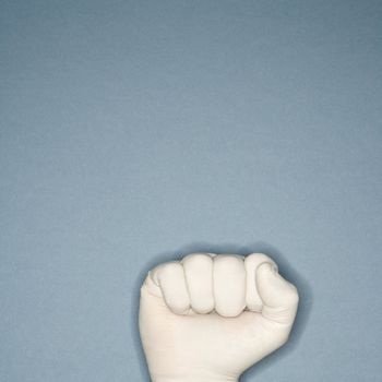 Fist wearing white rubber glove.