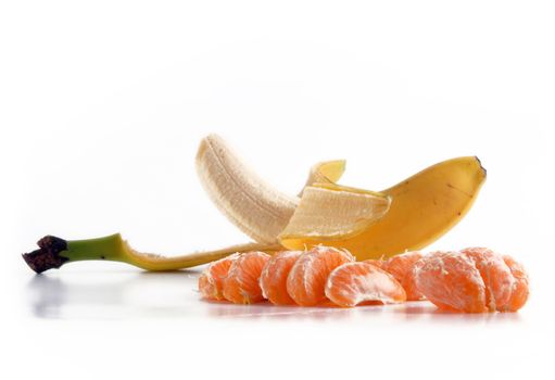 Ripe peeled banana and juicy tangerine slices on the floor