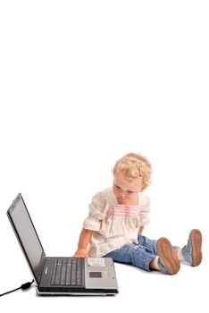 Baby girl looking curiously at a notebook on white background