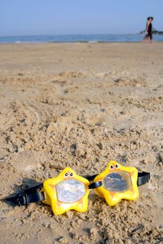 Toy swimming glasses star shaped on the sand.