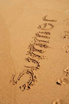 summer word hand made written on the sand on the beach