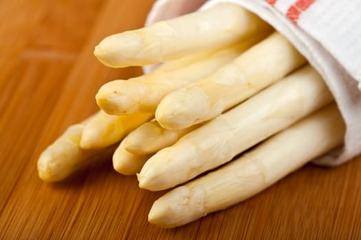 raw white asparagus on a wooden blank