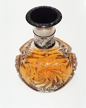 Glass bottle of perfume on white

