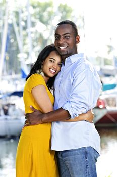 Young romantic couple hugging and standing at harbor