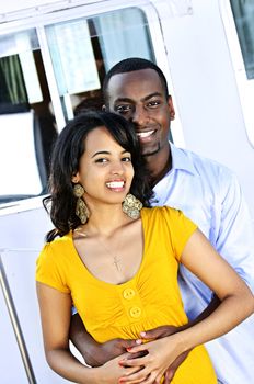 Portrait of young romantic couple hugging in front of yacht