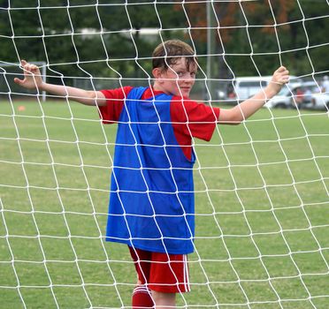 Soccer player in the net of the goal.                   