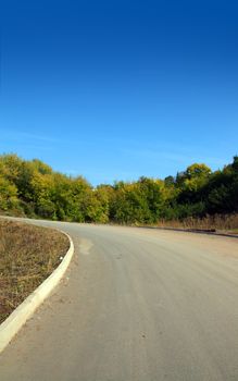curved road uphill under clear blue sky