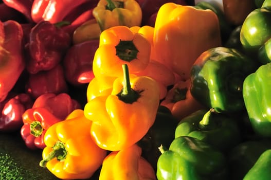 Red, yellow and green bell peppers arranged at a farmer's market