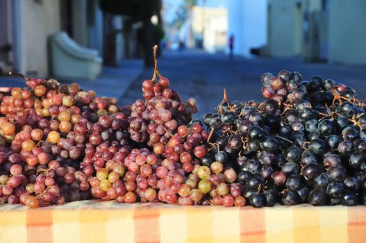 A variety of grapes for sale on a table at a farmer's market