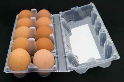 Ten eggs in packing on a black background