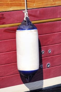 detail of fender protecting a red boat  