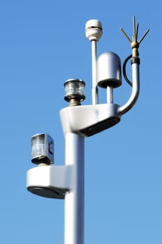 Detail of the top pole of a ship against a blue sky