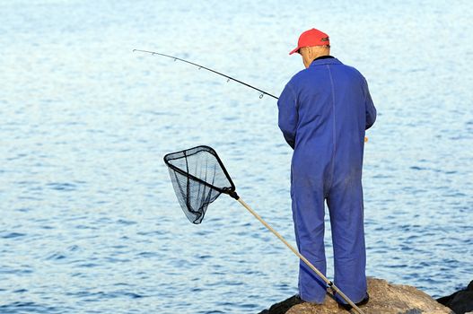 Fisherman with rod waiting for fishes