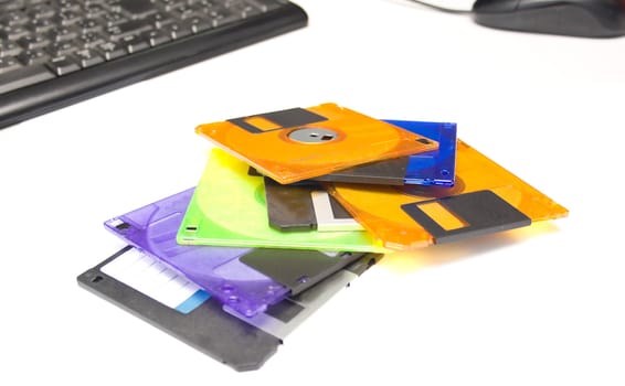 several diskettes of different color on white background. Isolation. Shallow DOF