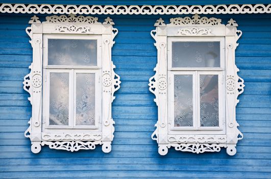 Two windows from old wooden red wall