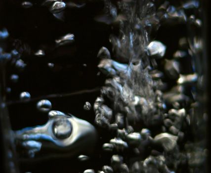 abstract bubbles reflecting light against a dark background
